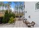 Well-maintained backyard with a stone patio featuring stylish seating, set against a backdrop of lush trees and manicured landscaping at 110 Jacoby Way, Chapel Hill, NC 27516