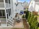 Landscaped backyard with a stone patio, outdoor seating, lush green trees, and a well-maintained lawn at 110 Jacoby Way, Chapel Hill, NC 27516