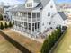 Aerial view of a white home's backyard featuring a screened porch and a stone patio nestled amongst lush trees at 110 Jacoby Way, Chapel Hill, NC 27516