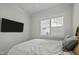 Bright bedroom featuring a comfortable bed, large window with blinds, and a mounted television at 110 Jacoby Way, Chapel Hill, NC 27516