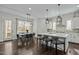 Spacious kitchen and dining area with island seating, modern lighting, and stainless appliances at 110 Jacoby Way, Chapel Hill, NC 27516