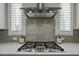Modern kitchen with a stainless steel range hood over gas cooktop and elegant gray tile backsplash at 110 Jacoby Way, Chapel Hill, NC 27516