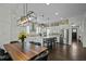 Open-concept kitchen and dining area with island seating, modern lighting, and stainless appliances at 110 Jacoby Way, Chapel Hill, NC 27516