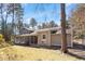 Exterior view showing the screened-in porch and spacious backyard surrounded by trees at 112 Celeste Cir, Chapel Hill, NC 27517