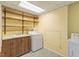 Cozy laundry room featuring a utility sink, washer and dryer, and open shelving at 112 Celeste Cir, Chapel Hill, NC 27517
