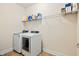Bright laundry room with washer, dryer, tile floor, and wire rack shelving for storage at 117 Oak Rise Ln, Fuquay Varina, NC 27526