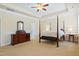 Spacious main bedroom with a four-poster bed, tray ceiling, and plenty of natural light at 117 Oak Rise Ln, Fuquay Varina, NC 27526