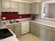Kitchen featuring gray cabinetry, white countertops, and a stainless steel sink at 12 Patriot Cir, Durham, NC 27704