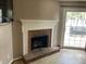 Living room featuring a red brick fireplace and a sliding glass door to the patio at 12 Patriot Cir, Durham, NC 27704
