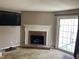 Living room featuring a red brick fireplace and a sliding glass door to the patio at 12 Patriot Cir, Durham, NC 27704