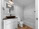 Neutral bathroom with a decorative mirror above the wood toned sink, with a shower and tub combo at 1213 Cotten Farm Dr, Fuquay Varina, NC 27526