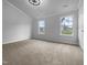 Bright bedroom features windows, neutral walls, and carpet at 1213 Cotten Farm Dr, Fuquay Varina, NC 27526