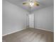 A simple bedroom with neutral carpet and gray walls, a ceiling fan, and two doorways at 1213 Cotten Farm Dr, Fuquay Varina, NC 27526