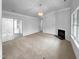 Spacious living room with sliding glass doors, a cozy fireplace, and neutral carpet at 1213 Cotten Farm Dr, Fuquay Varina, NC 27526