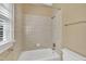 Tiled bathtub and shower with a window in the bathroom at 12404 Beauvoir St, Raleigh, NC 27614