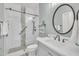 A remodeled bathroom featuring glass enclosed shower with gray accents, modern vanity, and updated lighting at 12404 Beauvoir St, Raleigh, NC 27614