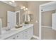 Bright bathroom with a double sink vanity and a large mirror at 12404 Beauvoir St, Raleigh, NC 27614