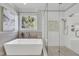 Modern bathroom featuring a soaking tub, glass enclosed shower, and tiled walls at 12404 Beauvoir St, Raleigh, NC 27614