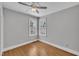 This is a light-filled bedroom featuring hardwood floors, neutral walls, and a modern ceiling fan at 12404 Beauvoir St, Raleigh, NC 27614