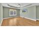 Bedroom features wood floors, tray ceiling, fan and tv hung on the wall at 12404 Beauvoir St, Raleigh, NC 27614