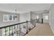 Open hallway with wrought iron railing overlooking living space and large bright windows at 12404 Beauvoir St, Raleigh, NC 27614