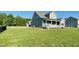 Back exterior view featuring a covered patio and ample yard space on a sunny day at 125 Scotland Dr, Youngsville, NC 27596
