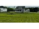 Lush backyard with a stone fire pit surrounded by chairs and a charming covered porch at 125 Scotland Dr, Youngsville, NC 27596