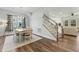 Dining area with wood floors, a dining table with chairs, a large window, and a staircase to the side of the room at 125 Scotland Dr, Youngsville, NC 27596