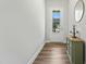 Hallway with hardwood floors, a round mirror, and a view of the front door at 125 Scotland Dr, Youngsville, NC 27596