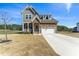 Beautiful two-story home featuring stone and gray wood, attached two-car garage, and a well-manicured front yard at 125 Scotland Dr, Youngsville, NC 27596