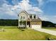 Charming two-story home featuring a combination of stone and siding with a manicured lawn at 125 Scotland Dr, Youngsville, NC 27596