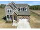 Charming home featuring stone and gray siding, a welcoming front porch, and a two-car garage at 125 Scotland Dr, Youngsville, NC 27596
