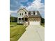 Charming two-story home featuring a combination of stone and siding with a manicured lawn at 125 Scotland Dr, Youngsville, NC 27596