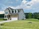 Charming two-story home featuring a combination of stone and siding on a manicured lawn at 125 Scotland Dr, Youngsville, NC 27596