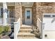 Inviting front entrance with stone steps, white railings, and a charming front door at 125 Scotland Dr, Youngsville, NC 27596