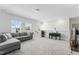 Spacious living room featuring carpeted floors, comfortable gray sofa and a piano at 125 Scotland Dr, Youngsville, NC 27596