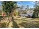 View of home's backyard, showing mature trees, shed, and screened porch at 1704 Cypress Dr, Henderson, NC 27536