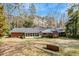 Backyard view of home showing a large grassy area, trees and screened in porch at 1704 Cypress Dr, Henderson, NC 27536