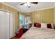 Cozy bedroom with paneled walls, a ceiling fan, window, and comfortable bedding for a relaxing retreat at 1704 Cypress Dr, Henderson, NC 27536