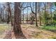 A brick home with a long driveway, surrounded by mature trees and landscaping at 1704 Cypress Dr, Henderson, NC 27536