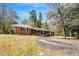 Ranch home with mature landscaping and covered front porch and long driveway at 1704 Cypress Dr, Henderson, NC 27536