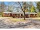 Classic single-story brick home with flowering trees and well-manicured landscaping at 1704 Cypress Dr, Henderson, NC 27536