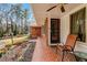 Charming front porch with brick accents, a seating area, and landscaped garden, creating a welcoming entrance at 1704 Cypress Dr, Henderson, NC 27536