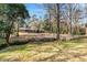 Charming brick home with mature trees and creek side appeal in lush green front yard at 1704 Cypress Dr, Henderson, NC 27536