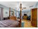 Serene main bedroom with a four-poster bed, warm lighting, and hardwood floors, creating a tranquil retreat at 1704 Cypress Dr, Henderson, NC 27536