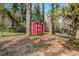 Storage shed in the backyard surrounded by mature trees and natural setting at 1704 Cypress Dr, Henderson, NC 27536