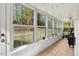 Light-filled sunroom with large windows and neutral tile flooring at 1704 Cypress Dr, Henderson, NC 27536