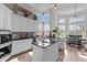 Bright kitchen featuring white cabinets, black granite countertops, and large windows at 199 Black Cloud Dr, Louisburg, NC 27549