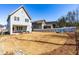 Expansive backyard with a covered patio, fire pit area with blue chairs, and privacy fence at 201 Bluffwood Avenue, Chapel Hill, NC 27516