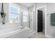 Bright bathroom featuring a soaking tub, glass-enclosed shower, and large window at 201 Bluffwood Avenue, Chapel Hill, NC 27516